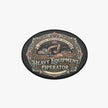 An oval-shaped black patch or badge featuring a vintage-style illustration of construction equipment and the text 'HEAVY EQUIPMENT OPERATOR' with 'SKILLED • PRECISION • QUALITY WORK' above it.