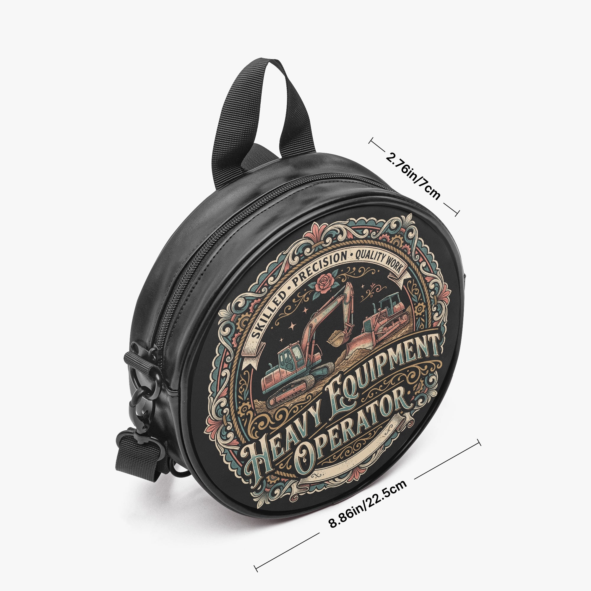 A black round crossbody bag with a vintage-style excavator graphic and text reading 'Heavy Equipment Operator.' Measurement lines and labels indicate dimensions of 2.