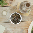 Bottle Opener with 'Plumber' design on a wooden table with a glass bottle and bottle cap.