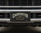 License plate with 'Carpenter' and 'Quality Craftsmanship' text on a work truck bumper