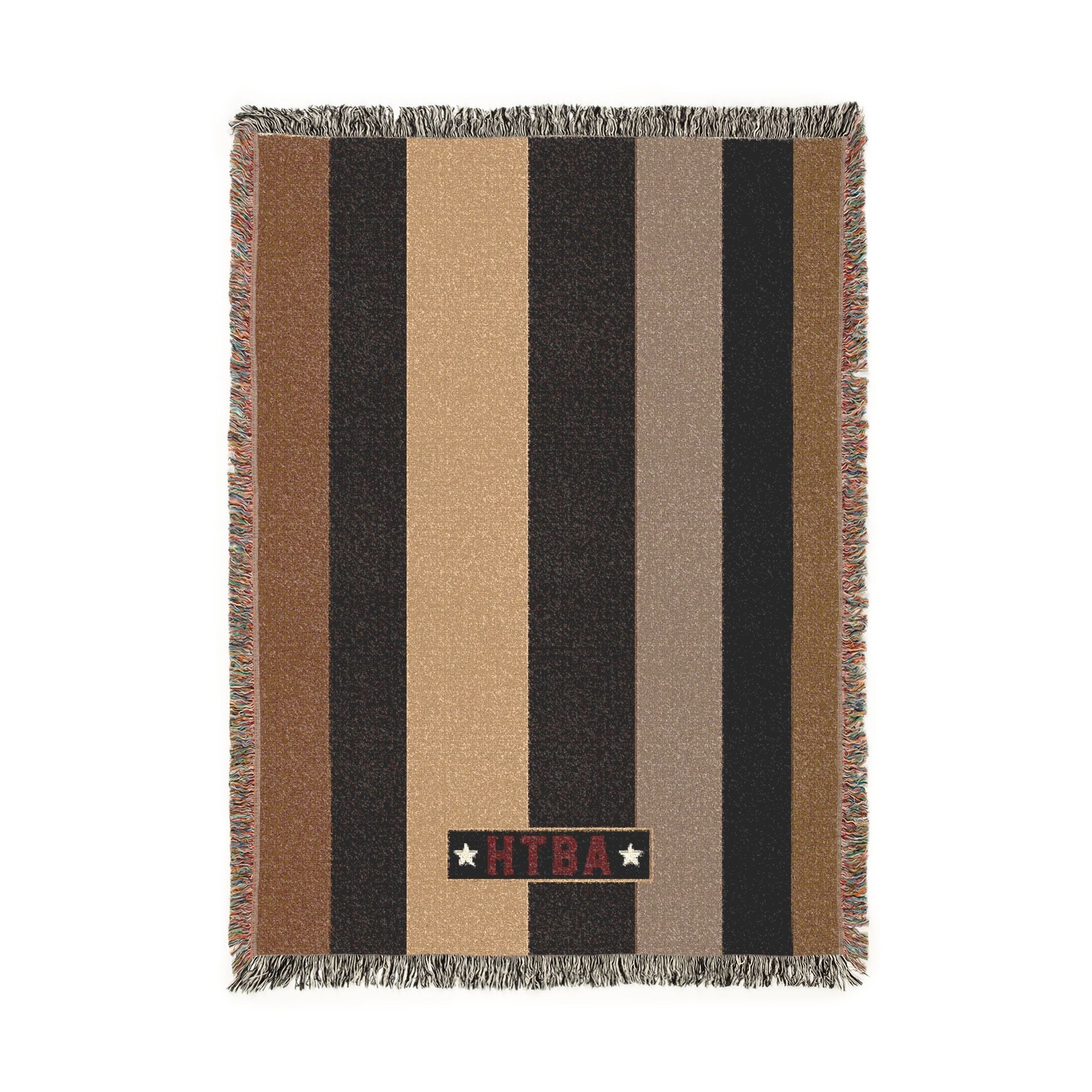 A rectangular woven throw blanket with horizontal stripes in brown, black, tan, and beige, finished with fringed edges and a vertical black brand tab reading 'KILTI' with two white stars.