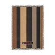 A rectangular woven throw blanket with horizontal stripes in brown, black, tan, and beige, finished with fringed edges and a vertical black brand tab reading 'KILTI' with two white stars.