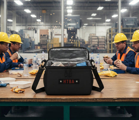 Black bag with 'HTBA' Hands That Build America branding in a factory setting
