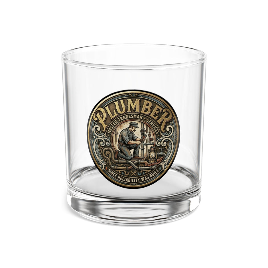 Clear glass tumbler with a 'Plumber' medallion on a white background