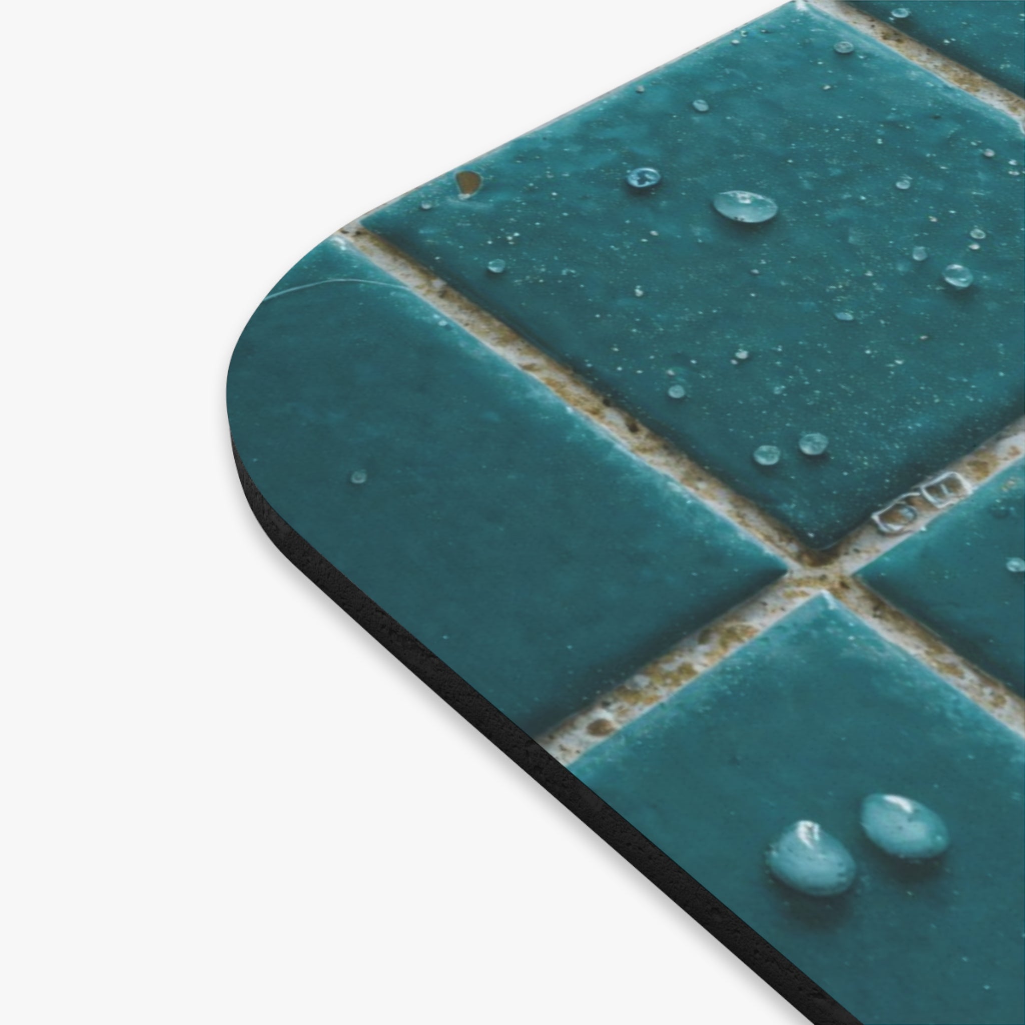 Close-up of teal ceramic tiles with water droplets on a white background