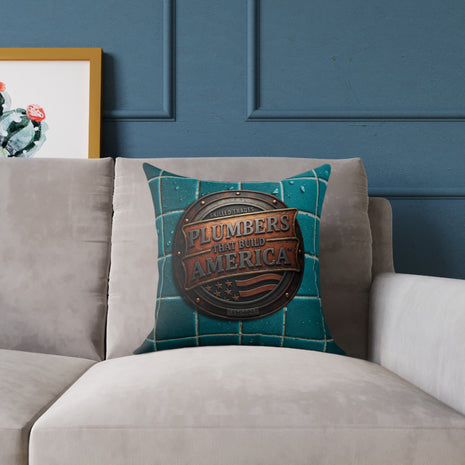 Decorative pillow with 'Plumbers That Build America' design on a gray sofa against a blue wall.