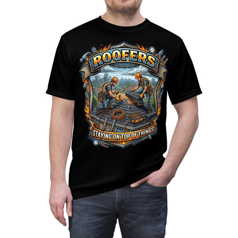 Black t-shirt with a graphic design of two roofer workers and text 'Roofers Staying on Top of Things' worn by a person.
