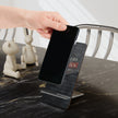 Person placing a smartphone on a Roofers phone stand on a marble surface.