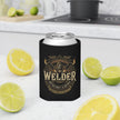 Welder's can cooler sleeve holding a silver aluminum can, placed on a white kitchen countertop with lemon and lime slices around it. The sleeve has a gold and beige graphic design with the word 'WELDER' and smaller text reading 'Metalcraft & Repair'