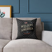 Decorative pillow with 'Welders That Build America' text on a gray couch against a blue paneled wall.