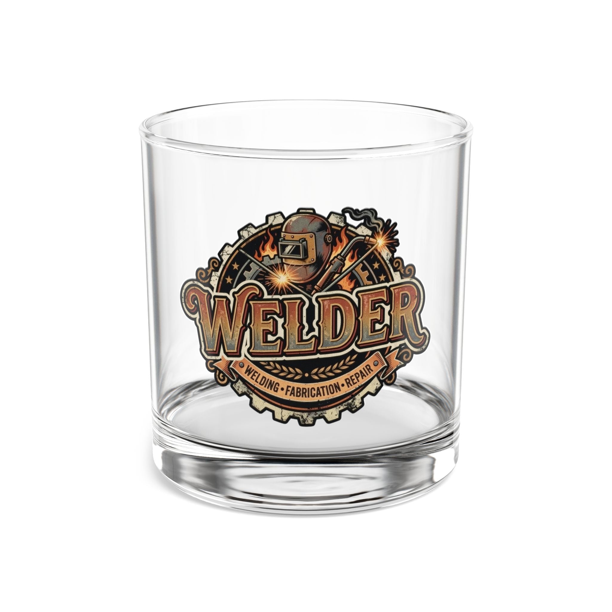 A clear glass rocks tumbler featuring a detailed 'Welder' graphic on the front, showcasing a welding helmet, sparks, and gears in a metallic gold and brown color scheme.